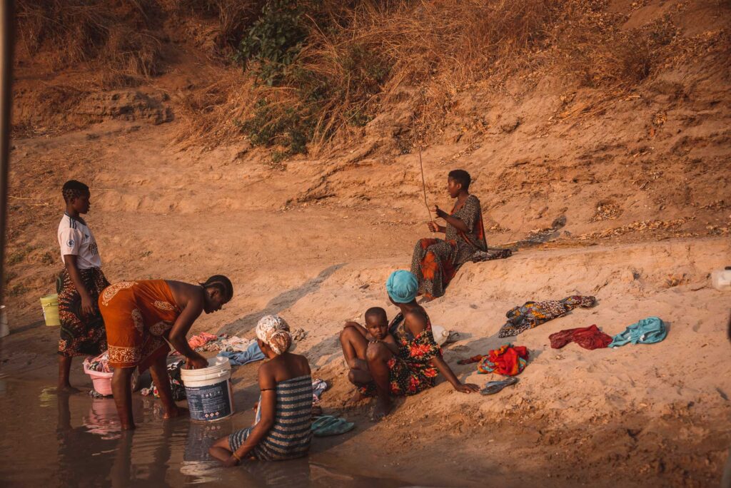 Kvinnor som tvättar kläder längs Rufiji River